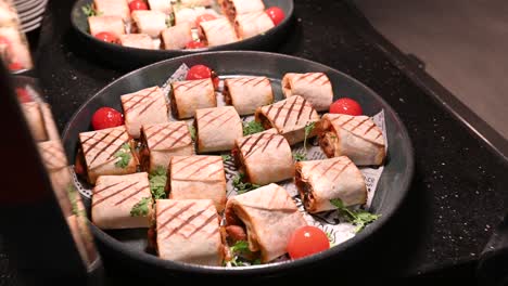 trozos de shawarma de pollo rellenos con salsa de barbacoa bajo una placa caliente