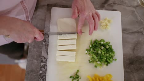 vista de arriba hacia abajo de la mujer cortando paneer en cámara lenta