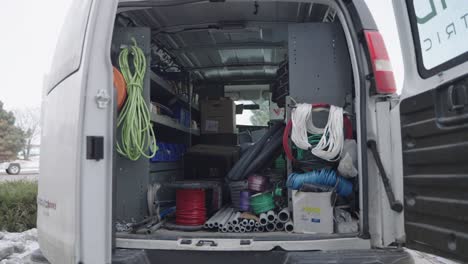detrás de una furgoneta de servicio de electricista blanco con equipos industriales, nadie