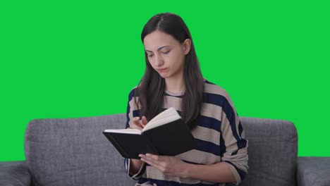 indian girl writing a book green screen