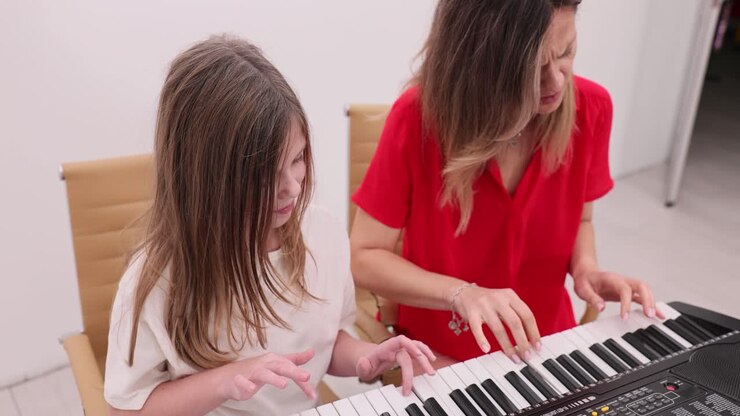 Woman and girl playing piano