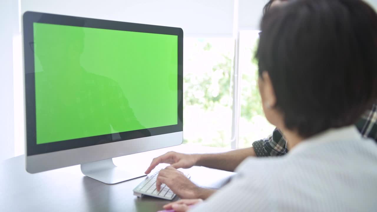 reunión de negocios. pequeña discusión de grupo de inicio en la habitación. joven asiático presentando a su equipo su idea en una computadora de pantalla verde. nuevo modelo de negocio comenzar conceptos.