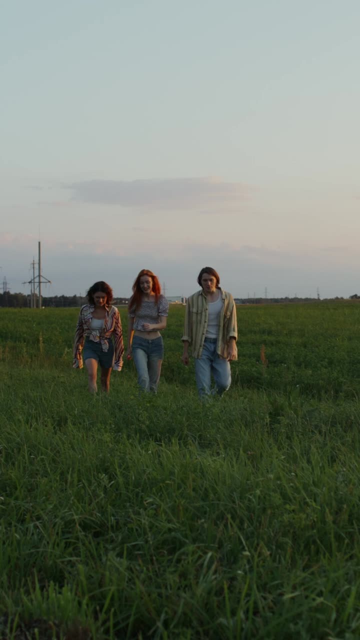 해가 지는 동안 들판에서 고 있는 친구들