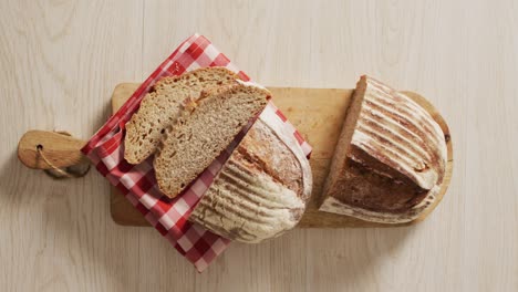 video of loaf of bread on chopping board on a wooden surface