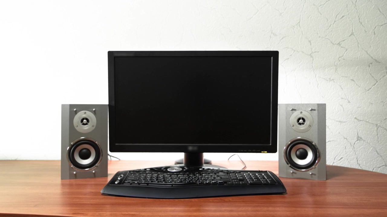 Work desk for digital job with computer, audio speakers and keyboard timelapse hyperlapse. Forward motion to the screen turning off and swithcing to black monitor
