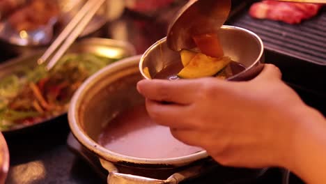 hands serving food into a bowl