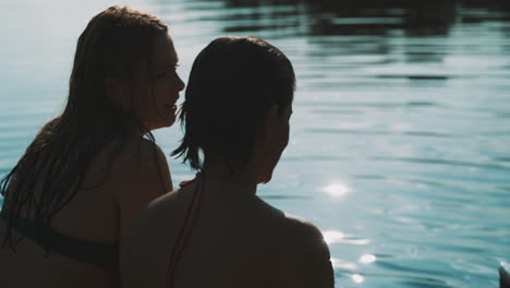 two women relaxing by the lake