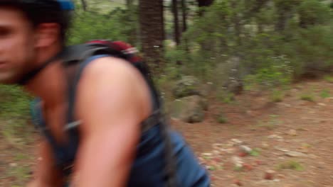 man biking through a forest