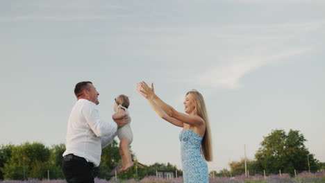 Happy-mom-and-dad-are-playing-with-their-little-daughter