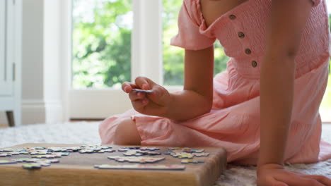 Nahaufnahme-Eines-Mädchens-Zu-Hause,-Das-Im-Wohnzimmer-Auf-Dem-Boden-Sitzt-Und-Puzzle-Macht