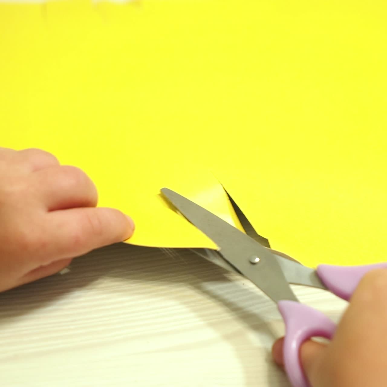 Child cuts paper with scissors. Early childhood education.