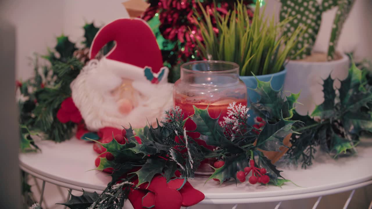 A Red candle surrounded by Christmas decor ignited by a barbeque lighter