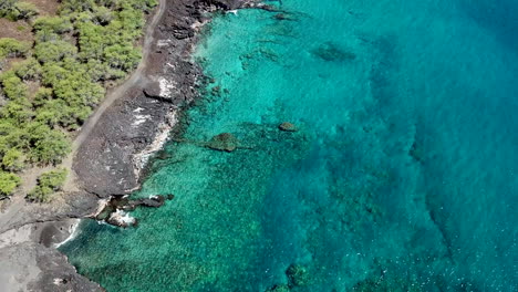 冰晶清晰的藍色水在夏威夷大島的黑色沙灘上