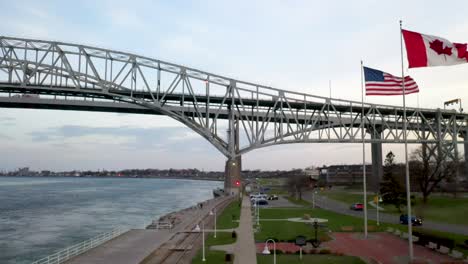 Bluewater-Bridge-connecting-Port-Huron,-Michigan-USA-and-Sarnia,-Ontario-Canada-with-flags-waving