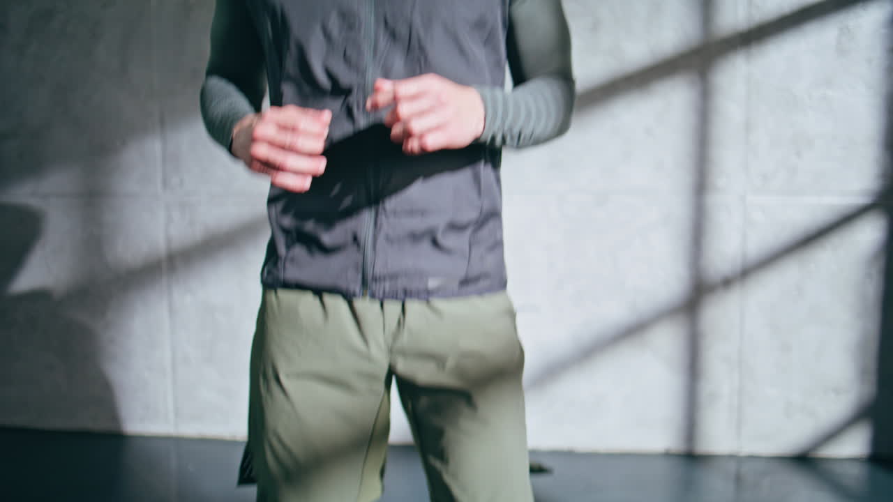 Athlete doing high knees exercise closeup. Unknown sportsman warming up jumping