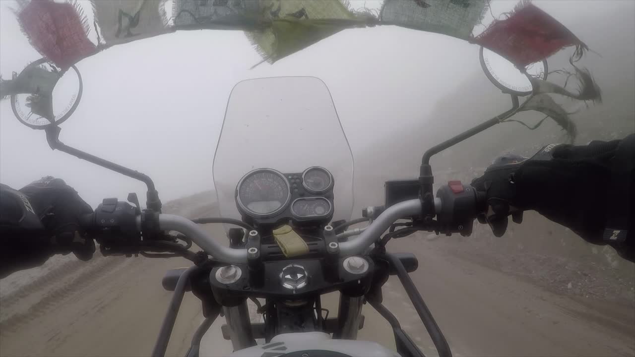 Motorbike with prayer flags attached driving through the fog in India in the Himalayan mountains