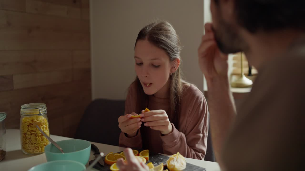 Family having breakfast with oranges and cereal