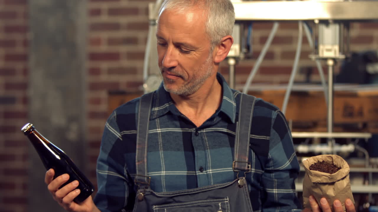 trabajador de la cervecería sosteniendo una botella de cerveza