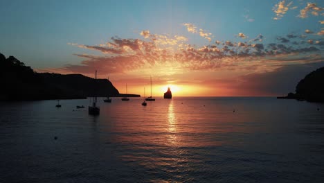 Beautiful-sunset-aerial-in-the-bay-of-Cala-Benirras,-Ibiza,-Spain