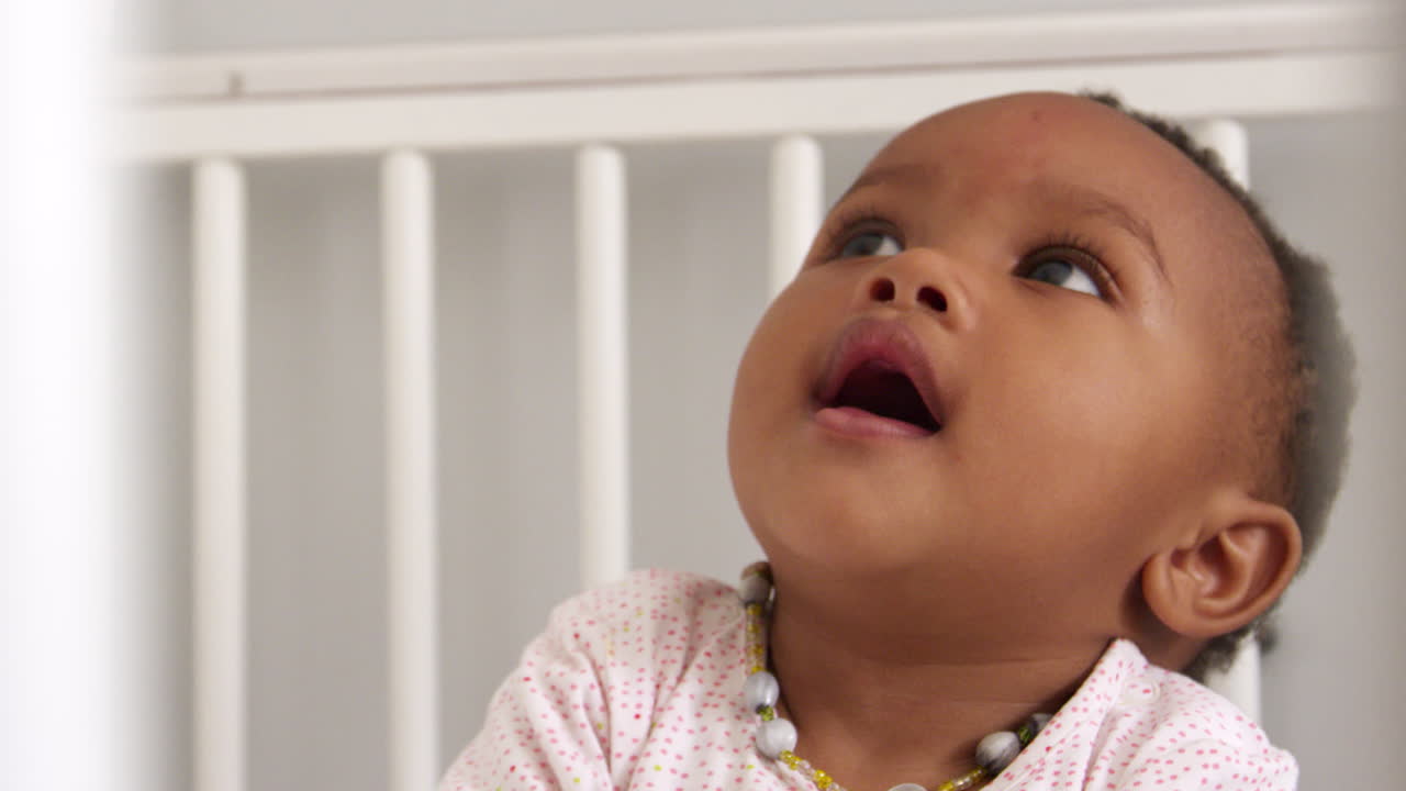 menina feliz brincando no berço da criança filmada em câmera lenta