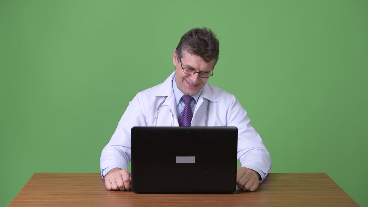 hombre maduro y guapo médico contra fondo verde