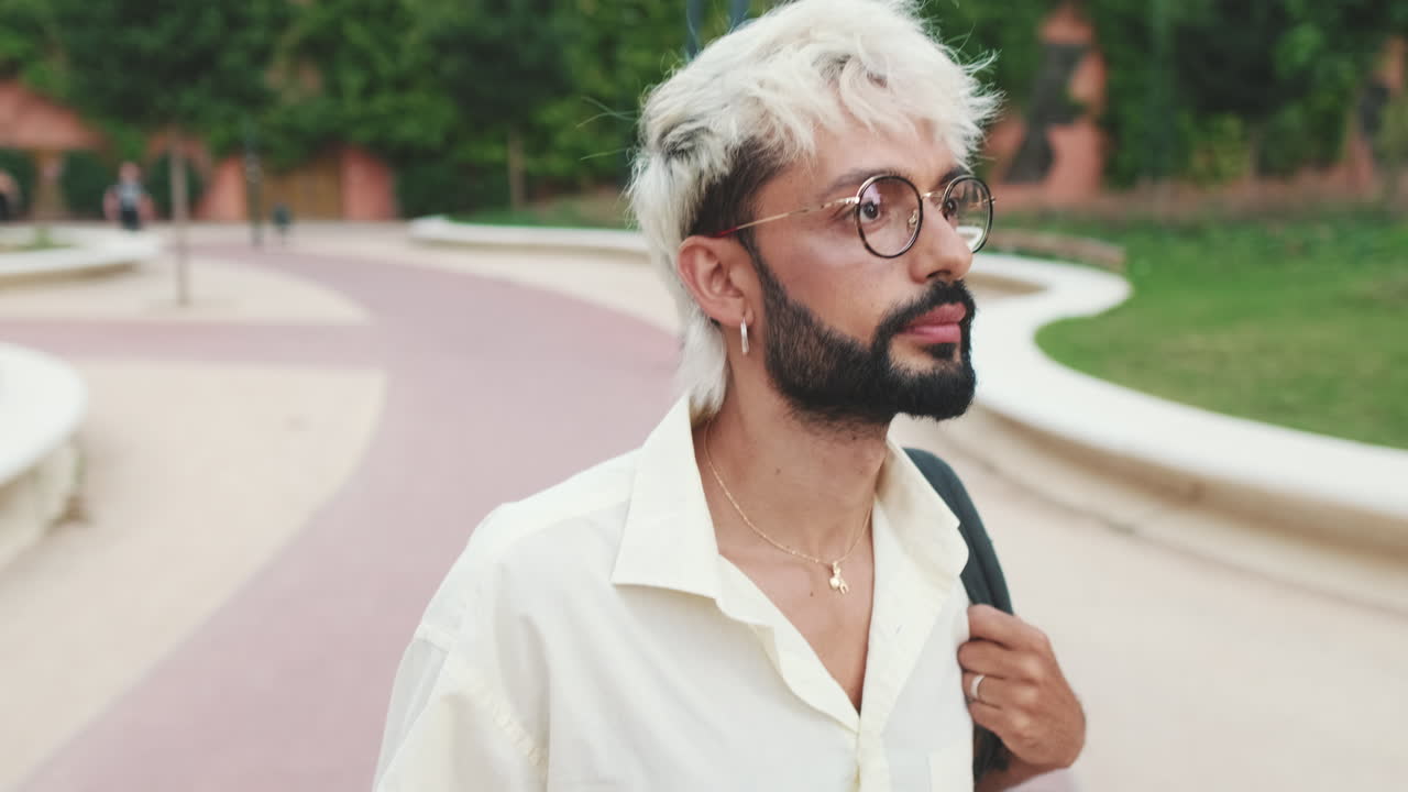 Stylish Young Man with Blonde Hair and Glasses in Park