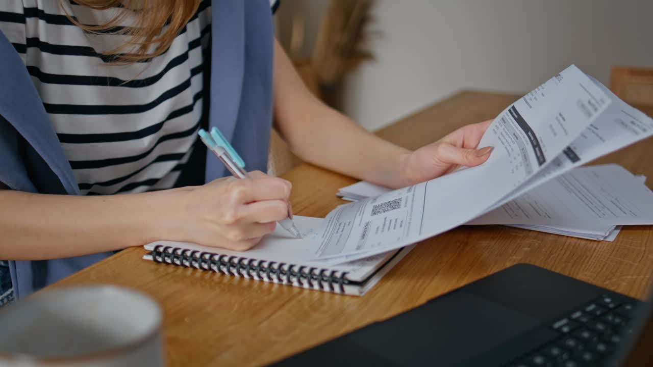 Lady hands reviewing paperwork coordinating tasks laptop closeup. Woman writing