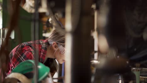 Dolly-Shot-Right,-Woman-Concentrates-Over-Project-in-Workshop