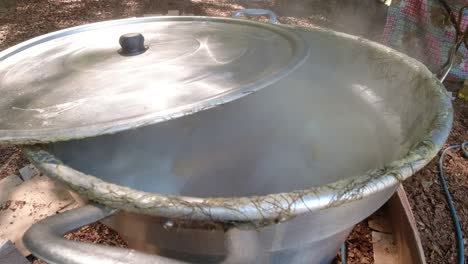 raw corn boiling in a big pan outdoors