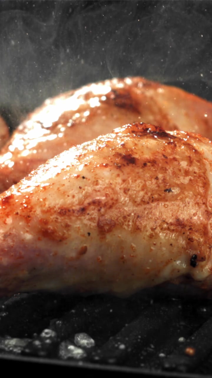 Fusi di pollo dorati che sfrigolano su una griglia calda.