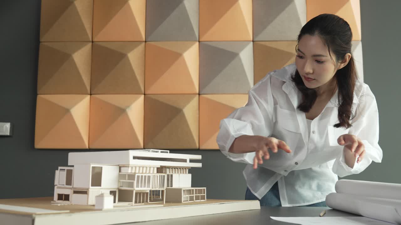 arquitecto profesional asiático mirando mientras revisa la casa modelo. manipulador.