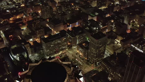 US-Bank-Tower-Rooftop-Helicopter-landing-pad-in-Los-Angeles-Skyline-at-Night,-Aerial-Tilt-down-revealing-lit-up-glowing-Cityscape-at-Dusk,-Circa-2019