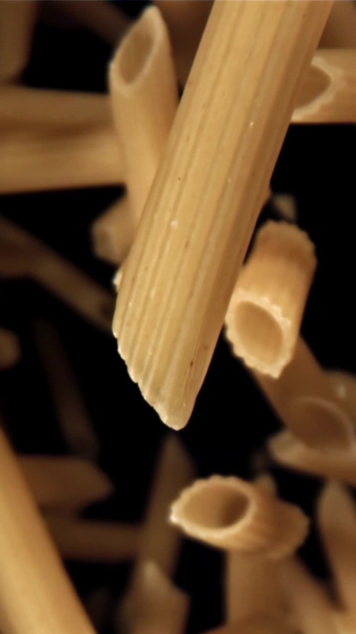 Primo piano di pasta penne che cade al rallentatore