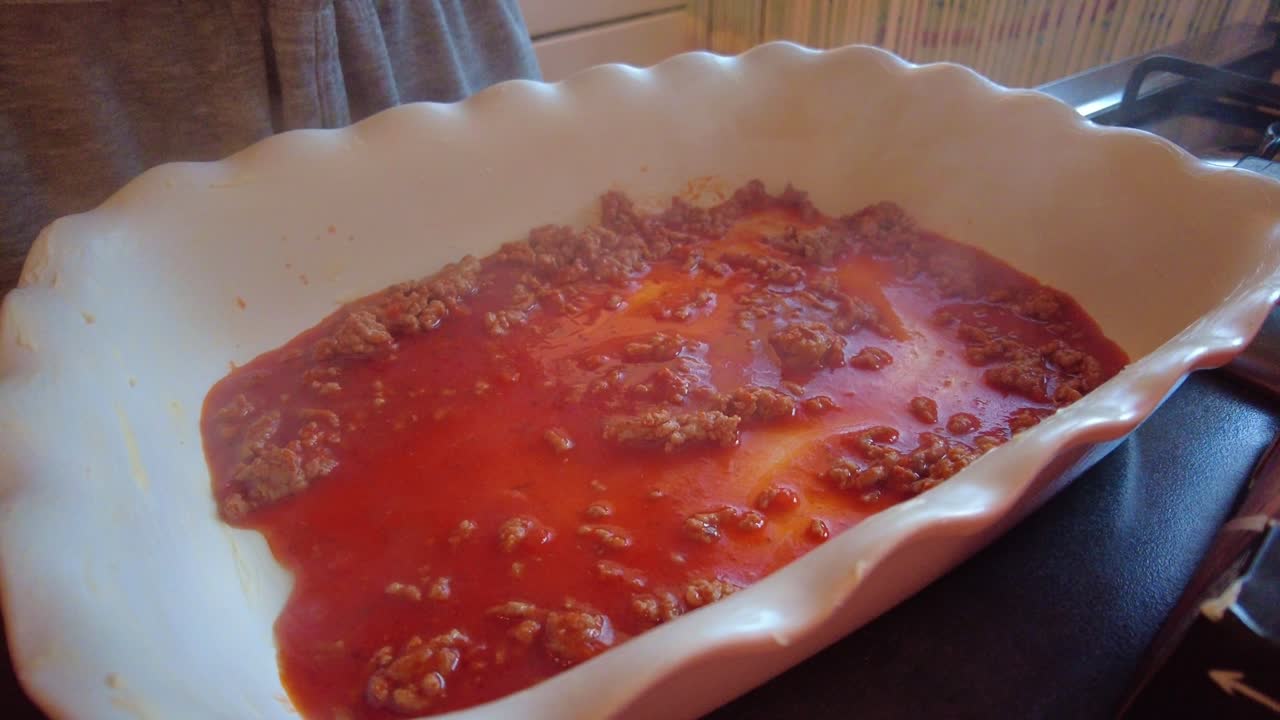 라자냐 파스타 시트가 접시에 담긴 뜨거운 증기 볼로네즈 소스 위에 놓여 있습니다.