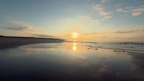 Eine-Ruhige-Szene-Fängt-Wellen-Ein,-Die-Ans-Ufer-Brechen,-Mit-Sonnenuntergangsfarbenen-Wolken-Am-Horizont,-Die-Die-Unberührte-Schönheit-Der-Abendlichen-Umarmung-Der-Natur-Verkörpern