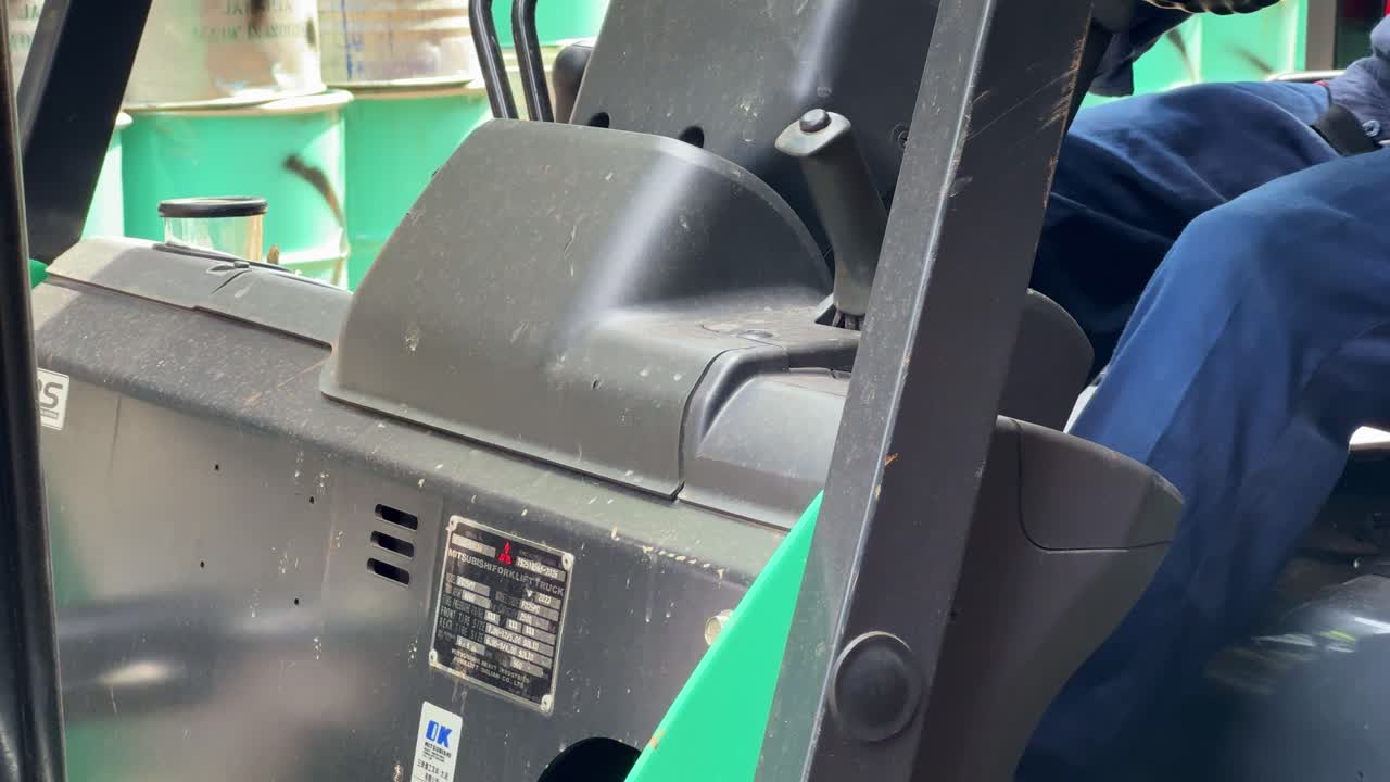 Hands-on forklift control as a worker drives through the work area