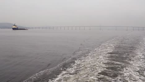 Boat-Backwash-At-Guanabara-Bay-With-Rio-Niteroi-Bridge-On-A-Misty-Day-In-Brazil