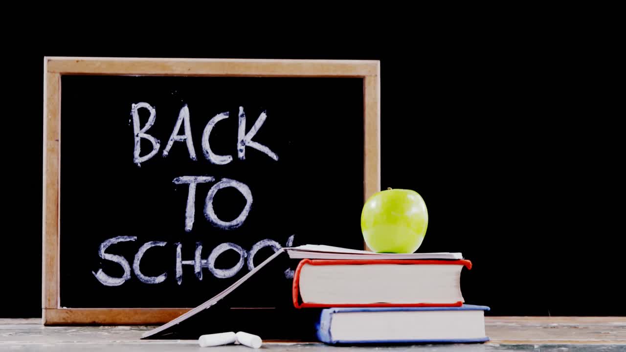 책 스택에 녹색 사과와 테이블에 슬레이트