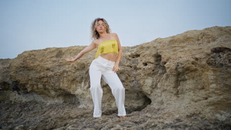 modern style dancer moving body smoothly on stone rock. woman performing dance