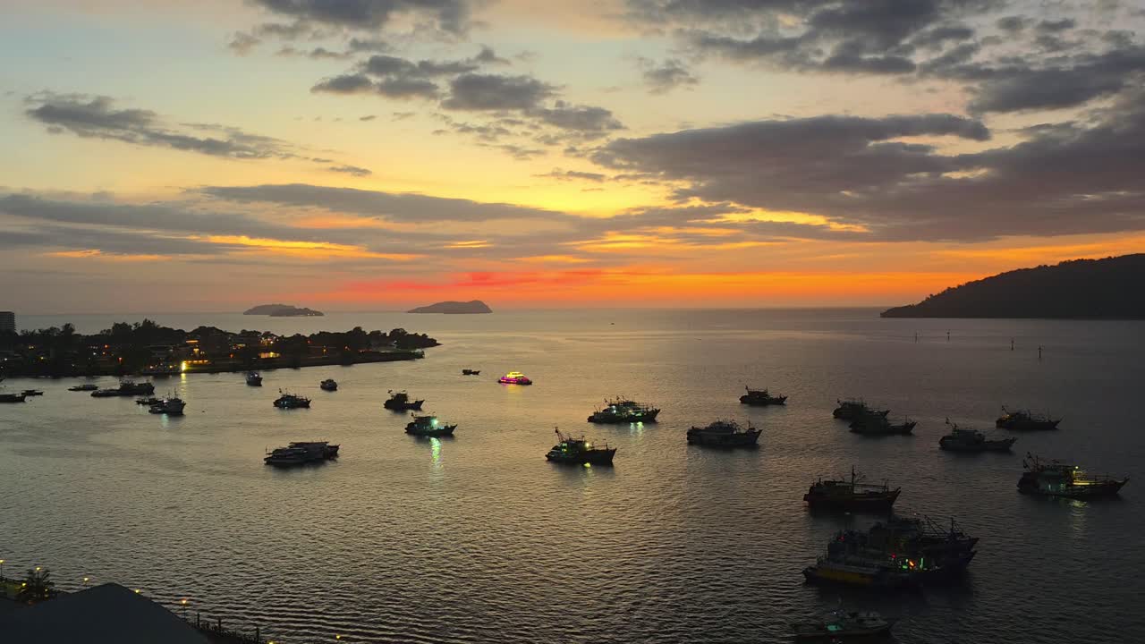 Aerial Panoramic View of Kota Kinabalu Waterfront Dock at Sunset, View of Many Moored Fishing Boats by the Coast in Silhouette, and Isles in Backdrop