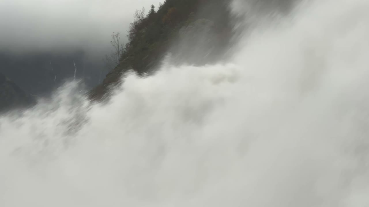 Primo piano mobile con panoramica dell'enorme flusso d'acqua alla base delle potenti cascate Nugget sul lago Mendenhall vicino a Juneau, Alaska. Video 4K