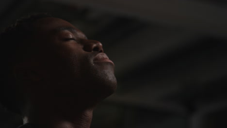 close up of unhappy and depressed young man sitting on sofa at home at night closing eyes and putting head in hands 3