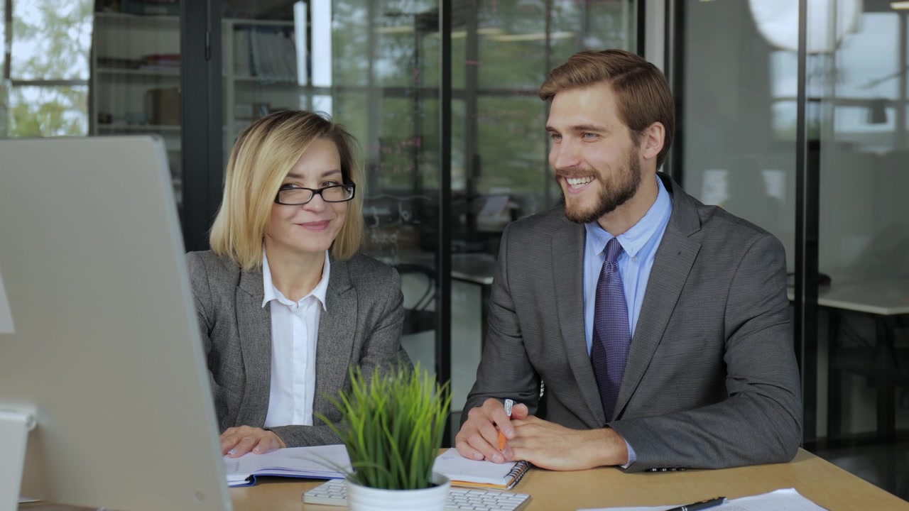 Due professionisti d'affari che collaborano e discutono idee in un ufficio moderno