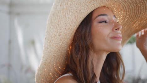 sombrero de paja morena posando ciudad con rostro sonriente retrato. modelo buscando cámara