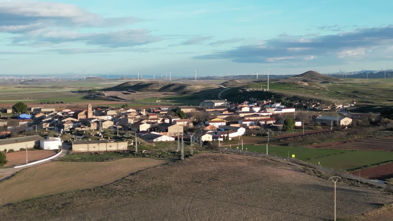 Aerial view of Spanish town Pozuelo de Aragón with wind turbines in the distance.