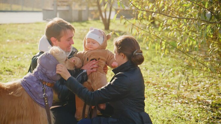Legame familiare nella natura: un momento speciale con un bambino, i suoi genitori e il loro simpatico cane in una splendida giornata al parco, circondati dai colori autunnali