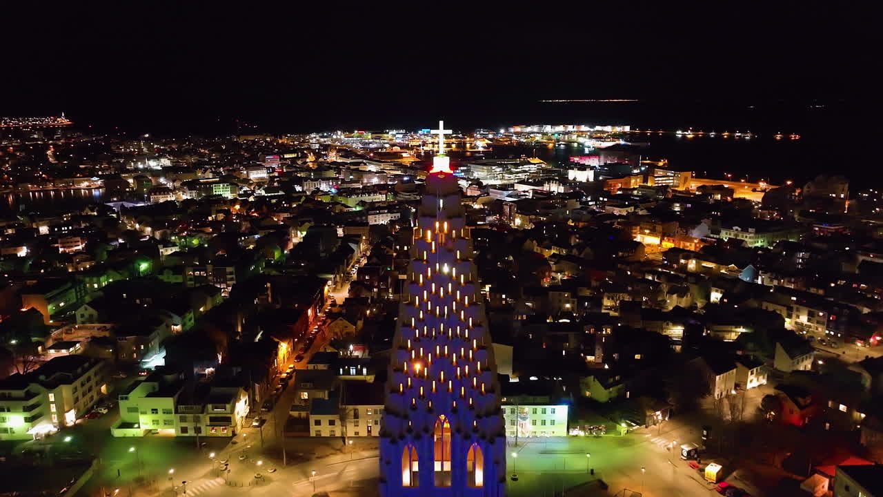 Drone approaching the cross on the Hallgrímskirkja church, night in Reykjavik, Iceland