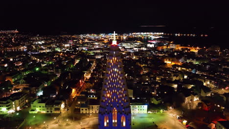 drone approaching the cross on the hallgrímskirkja church, night in reykjavik, iceland