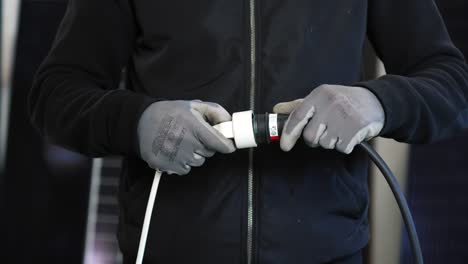 electrician with gloves putting in the plug