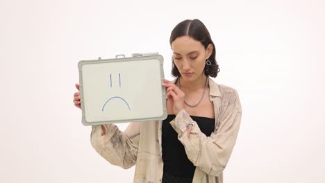 woman showing a sad face on a whiteboard
